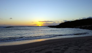 Dalgalar sahile inci üzerinde hareket ile Okyanusu güzel gün batımı