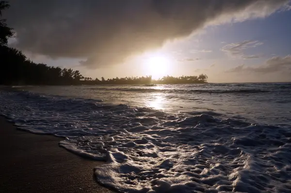 Hermoso atardecer sobre el océano con olas moviéndose a través del san —  Fotos de Stock