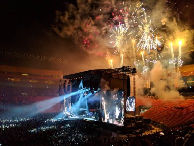 Honolulu, Hawaii - 8 Aralık 2018: Guns N 'Roses sahnede havai fişekler patlarken ve kalabalık Aloha Stadyumu' nda tezahürat yaparken müzik çalıyor. Guns N 'Roses, kısaca GNR, 1985 yılında Los Angeles, Kaliforniya' da kurulan Amerikalı hard rock grubu..