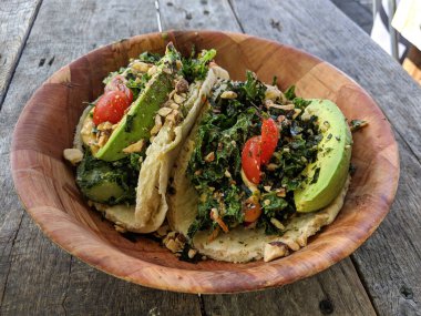 Zencefilli tahin sosuyla karışık salata soslu sörf tacoları. Üzerine sarımsaklı fasulye serpiştirilmiş sıcak pita, üstüne avokado, üzüm domatesleri, furikake ve badem..