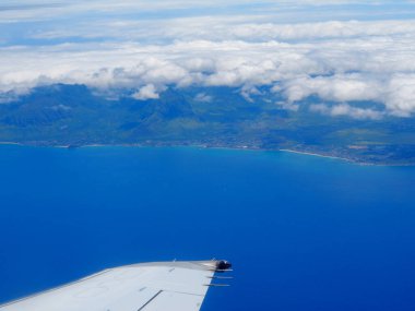Makaha ve Waianae açıklarında, üzerinde bulutlar olan ticari bir jet uçağının kanatları Oahu adasında..