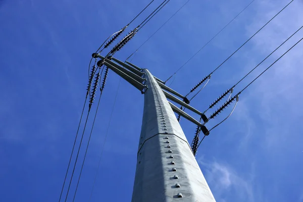Nagyfeszültségű vezetékek metszik egymást egy nagy fém közüzemi pole — Stock Fotó