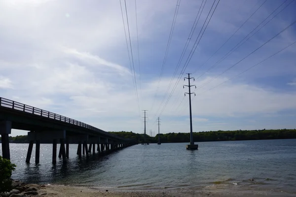 Brücke und Stromleitungen überqueren Wasserstraße — Stockfoto