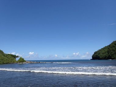 Honomanu Park, siyah kum plaj dalgalar kucağında