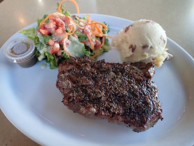 New York Steak, patates püresi ve dre ile beyaz tabak salataya
