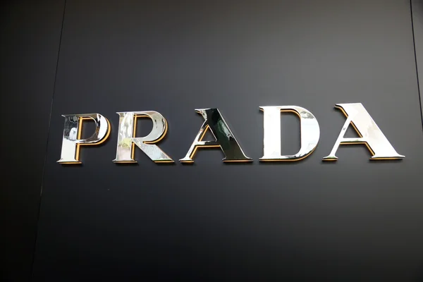 Logotipo Prada ouro na parede preta — Fotografia de Stock