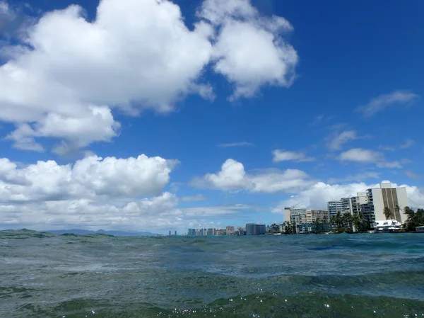 Ocean waters ripple off the coast of waikiki with hotels lining — Stock Photo, Image