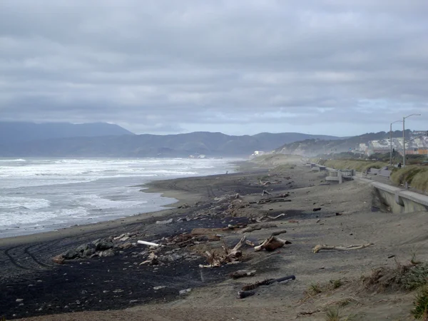 Ondas regazo en Ocean Beach con madera, rocas, camino — Foto de Stock