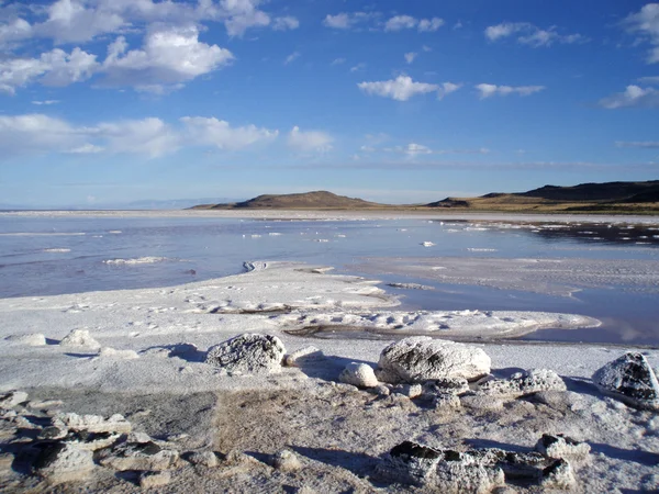 Felsiges, salziges Ufer und Wasser des großen Salzsees mit Berg — Stockfoto