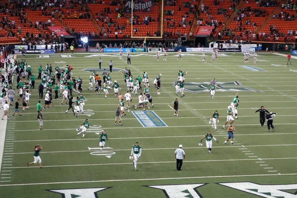Spieler und Fans hawaiianischer Universität stürmen das Spielfeld, um Promis zu feiern — Stockfoto