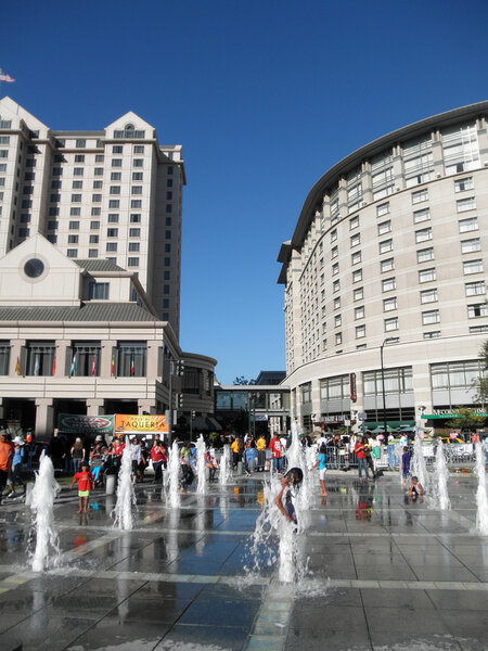  Kids play in the interactive water jets fountain