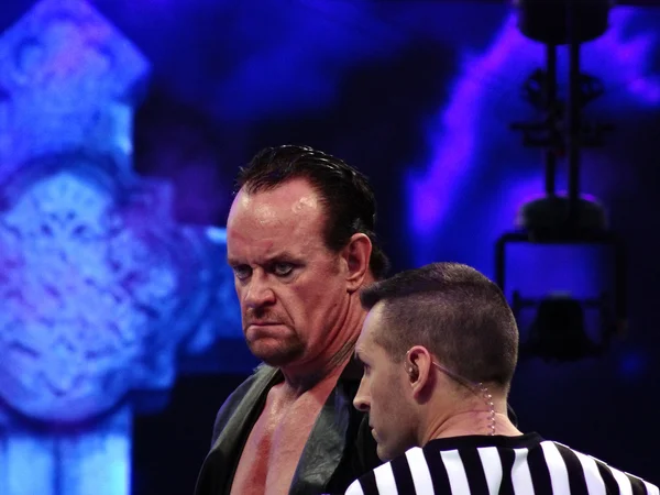 WWE Wrestler the Undertaker mira al otro lado del ring con ref de pie — Foto de Stock