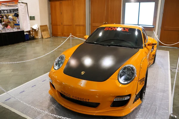 Orange Porsche auto na displeji v autosalonu — Stock fotografie