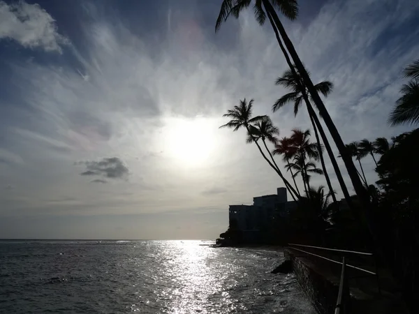 Zonsondergangen over wateren van Waikiki zoals golven crash op de Zeedijk bij Makale — Stockfoto