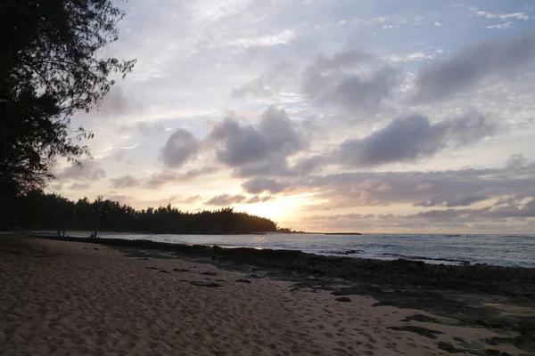 Sunset through the clouds and reflecting on the waves as they br — Stock Photo, Image