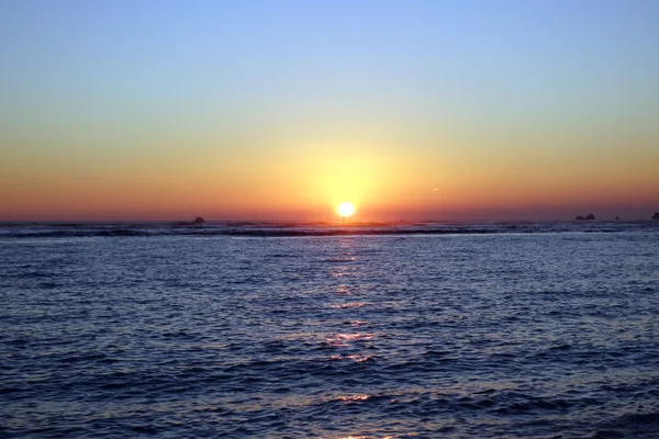 Lodě do vody při západu slunce nad oceánem — Stock fotografie