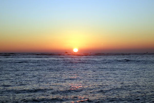 Båtar och boj i vattnet under solnedgången över havet — Stockfoto