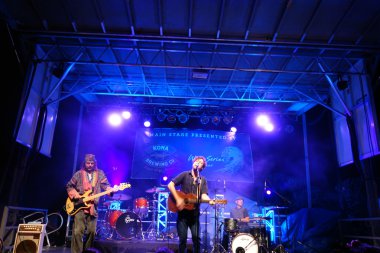 Roothub sings into mic as he performs on stage during a evening 