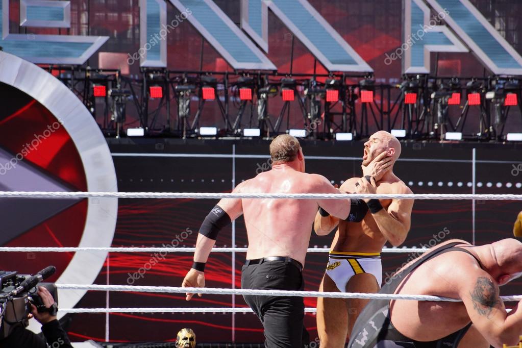 WWE Wrestler Kane puts hand around neck of Cesaro to setup for a