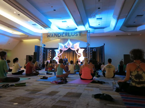 Author and teacher Max Storm teaches yoga class from a stage to — Stockfoto