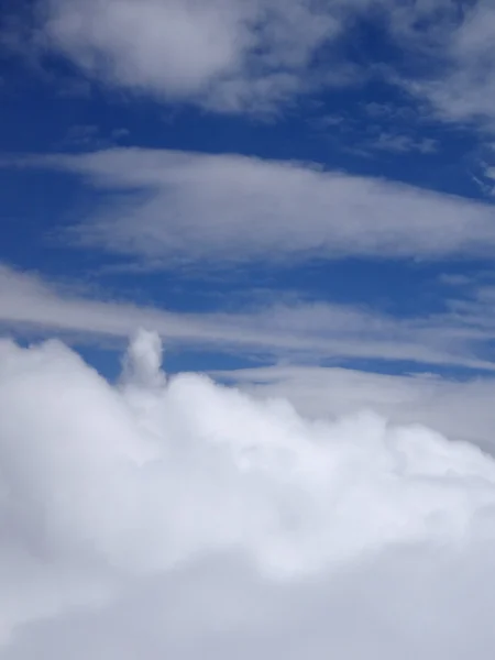 Nubes esponjosas arriba y abajo en un cielo azul — Foto de Stock