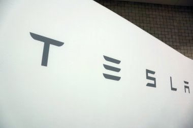 Beyaz Tesla işareti ile Motor Show Fuarı nda gri metin