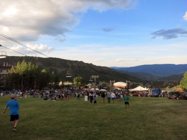 İnsanlar ve çocuklar değnek sırasında konser alanına teleferik ile izlemek