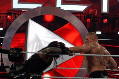 29 Mart 2015 - Santa Clara, CA: İki güçlü güreşçi büyük bir güreş müsabakasında ringde çarpıştı, parlak ışıklar altında güçlerini ve yeteneklerini sergilediler ve tezahürat yapan seyirciler.