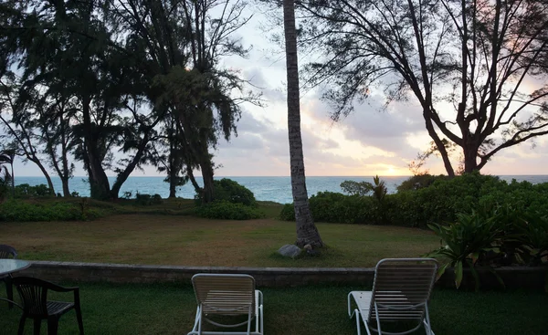 Liegestühle im Strandhof mit Blick auf den Sonnenaufgang am frühen Morgen — Stockfoto