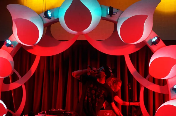 MC Yogi canta no microfone com DJ Drez atrás dele em concerto indoor — Fotografia de Stock