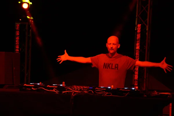 Moby holds arms out on stage during concert — Stock Fotó