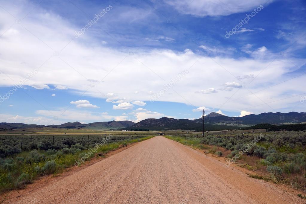 Dirt Desert Road and Blue cloudy Sky