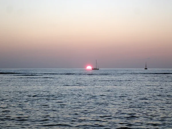 Solnedgång över Waikiki Ocean med båtar i vatten — Stockfoto