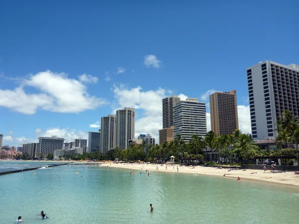 People play in the protected water and hang out on the beach in — Stock Photo, Image