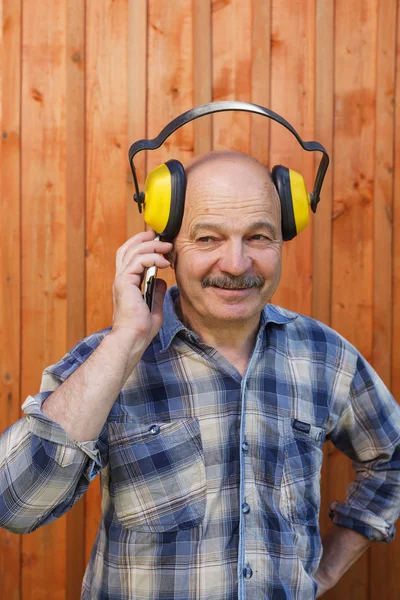 Trabajador de la construcción en auriculares protectores durante una charla de descanso — Foto de Stock