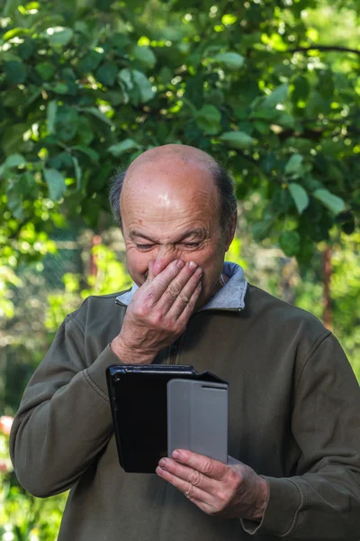Homem idoso com nariz escorrendo à procura de cura na Internet — Fotografia de Stock
