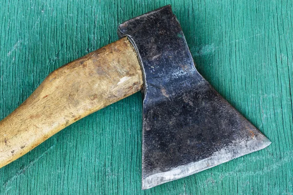 Velho machado de ferro deitado em uma superfície de madeira . — Fotografia de Stock