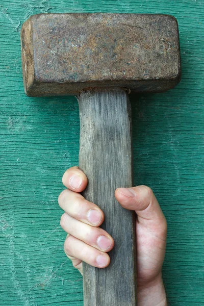 The white man's hand grabs the hammer. — Stock Photo, Image