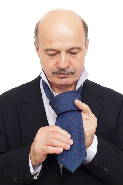 Homem de negócios idoso cuidadosamente amarrando um laço — Fotografia de Stock