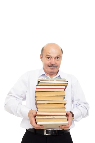 Homem mais velho em uma camisa branca segurando uma pilha pesada de livros — Fotografia de Stock