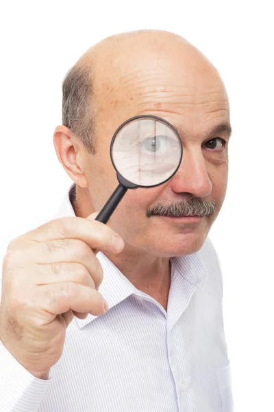 Oudere man kijkt iets door een vergrootglas. — Stockfoto