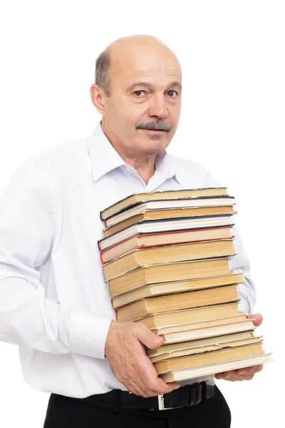 Homem mais velho em uma camisa branca segurando uma pilha pesada de livros — Fotografia de Stock