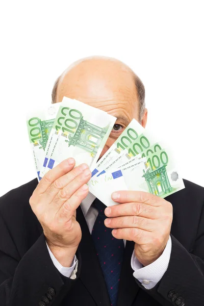 Elderly man hides beside money Stock Image