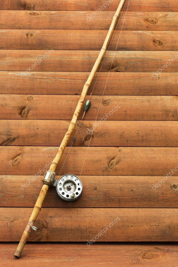Old fishing rod on wooden background — Stock Photo © Koldunov
