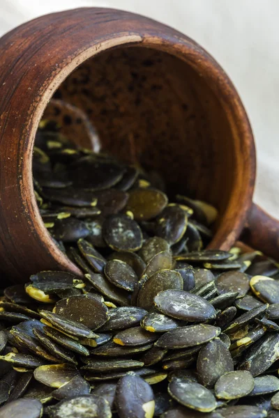 Les graines de citrouille pelées sont dans une tasse en terre cuite . — Photo