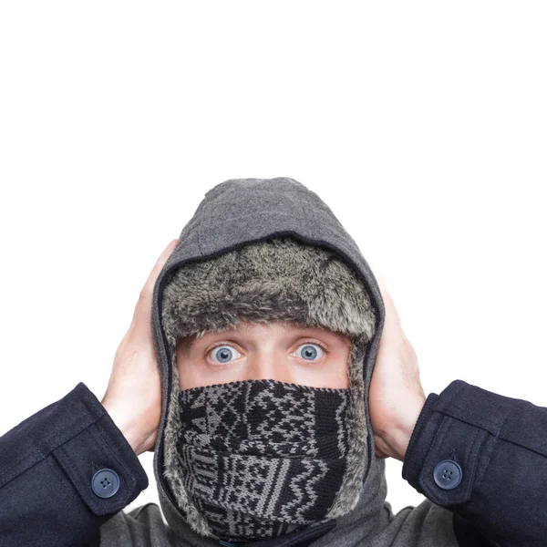 Mladý muž v čepici, šálu a kapucí skrývá před chladným počasím v — Stock fotografie
