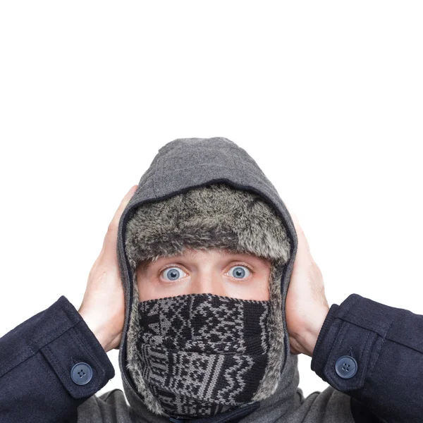 Young man in hat, scarf and hood hiding from the cold weather in Stock Photo