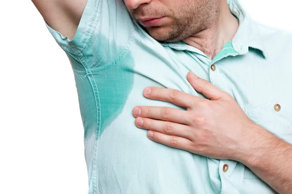 Un joven horrorizado mirando la camisa sudorosa — Foto de Stock