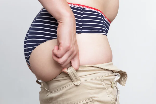 Біла жінка, намагаючись витягнути штани на жирну дупу — стокове фото