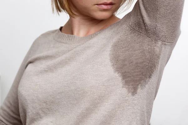 Mujer joven mirando la camisa sudorosa — Foto de Stock